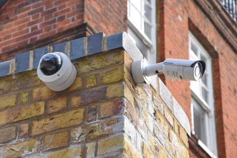 Smart security cameras utilizing face detection technology are mounted on the outside of a building.