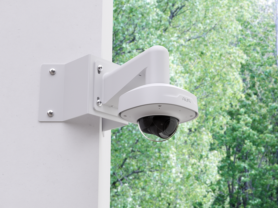 a person installing a security camera on a bricked wall 