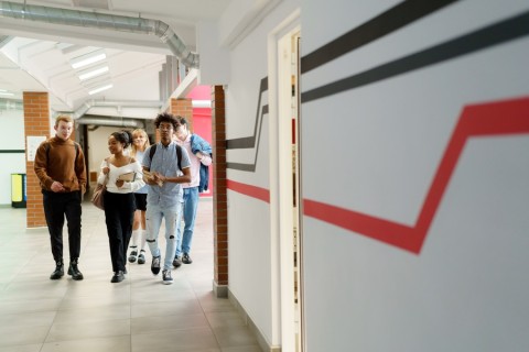 A group of students walking in a school hallway.